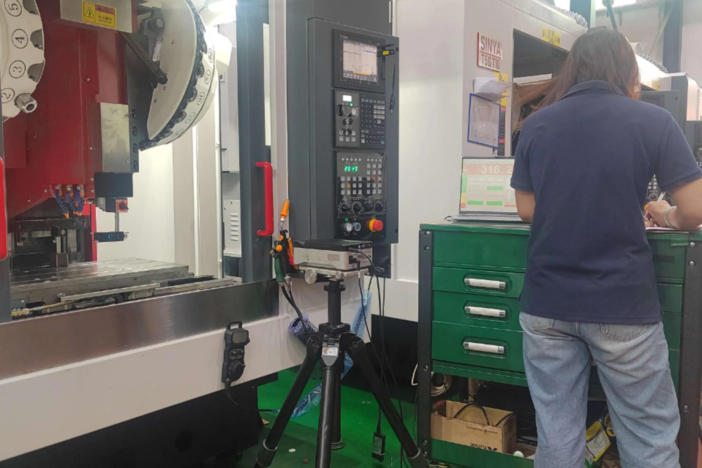 Worker beside a SINYA machine in an approved company-material production image.
